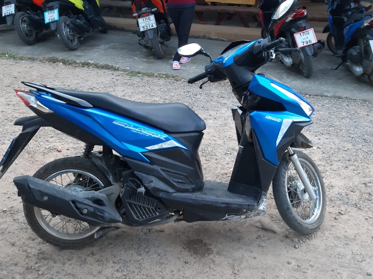 Honda Click 125 синего цвета, вид сзади, с тайским номерным знаком.