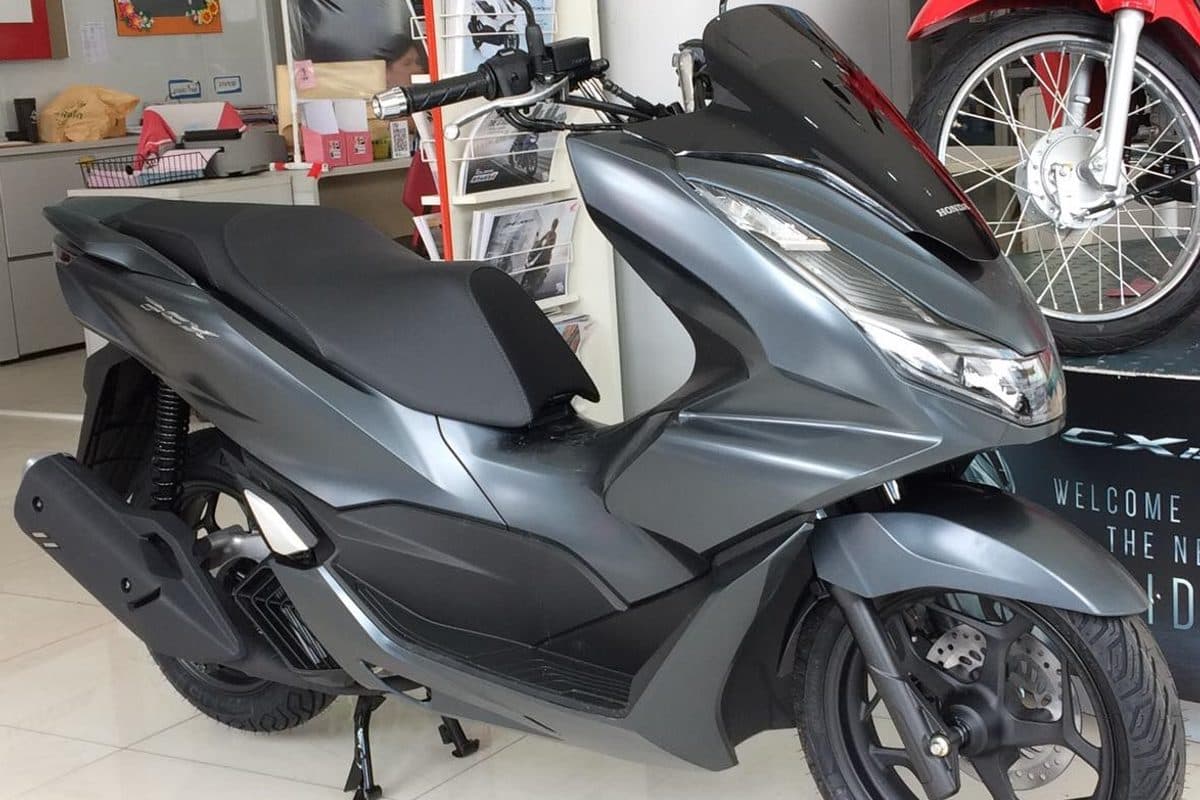 Настоящий скутер Honda PCX 160 матово-серого цвета в шоуруме дилера